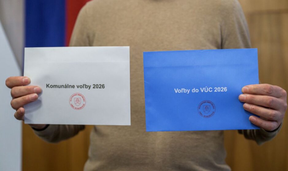 Na snímke muž drží volebné obálky sprava pre voľby do VÚC (modrá farba) a komunálne voľby (biela farba). Foto: TASR - Veronika Mihaliková